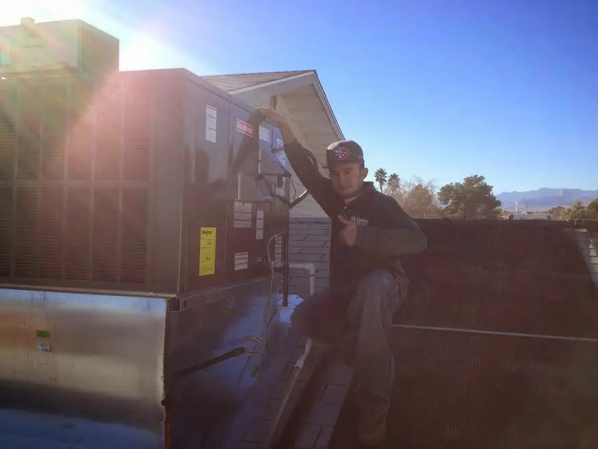 HVAC technician performing Heat Pump Repair on a rooftop unit in Arlington